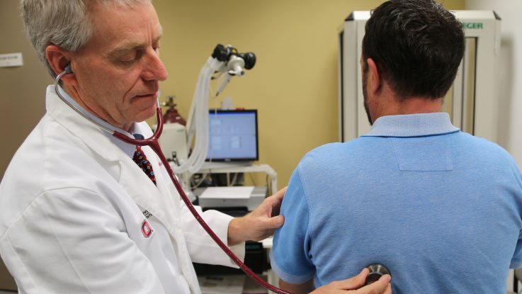 Dr. Elliott Crouser listens to the lungs of a patient at The Ohio State University Wexner Medical Center. He is conducting a clinical trial to see if nicotine patches can treat sarcoidosis, a chronic lung disease that is commonly triggered by inhaling pesticides or other harmful materials.
